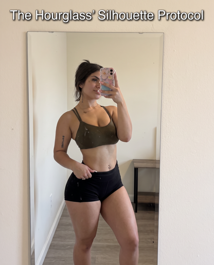 Woman in a brown sports bra and black high-waisted shorts taking a mirror selfie, with 'The Hourglass' Silhouette Protocol' text overlaid at the top